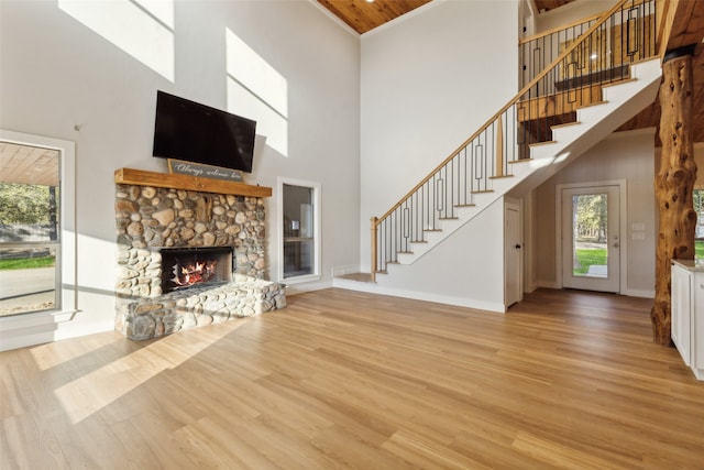 unfurnished living room with a fireplace, light hardwood / wood-style flooring, and a high ceiling