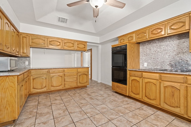 kitchen featuring sink, backsplash, a tray ceiling, light tile patterned floors, and black appliances