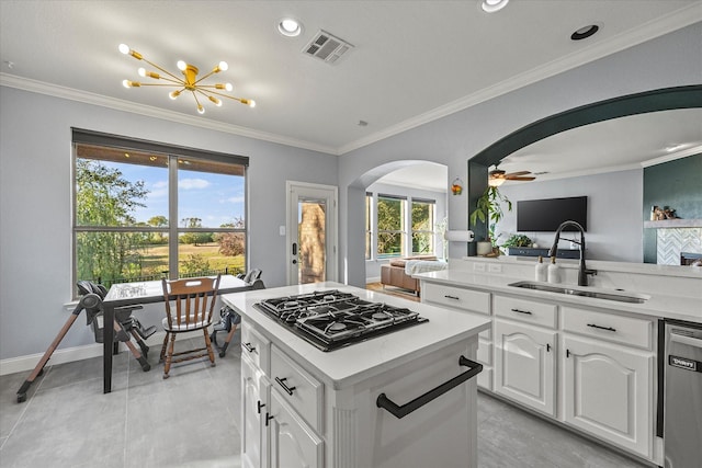 kitchen with sink, crown molding, white cabinetry, stainless steel appliances, and ceiling fan with notable chandelier