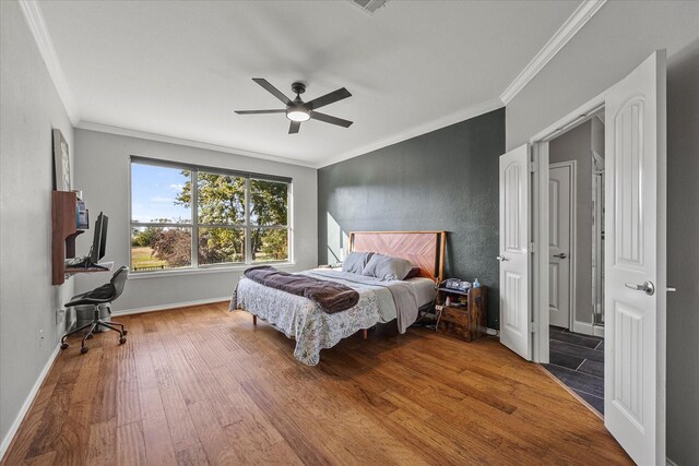 bedroom featuring hardwood / wood-style floors, crown molding, and ceiling fan