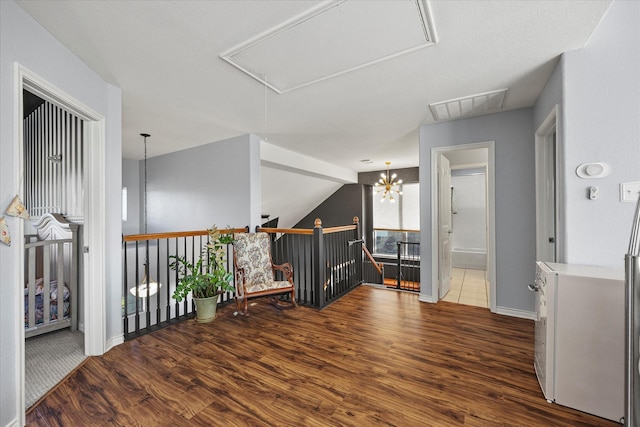 corridor featuring dark wood-type flooring, a chandelier, and vaulted ceiling