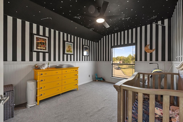 bedroom featuring ceiling fan, carpet flooring, and a crib