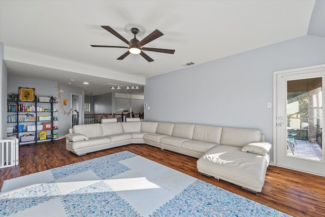 living room featuring dark wood-type flooring, ceiling fan, and vaulted ceiling