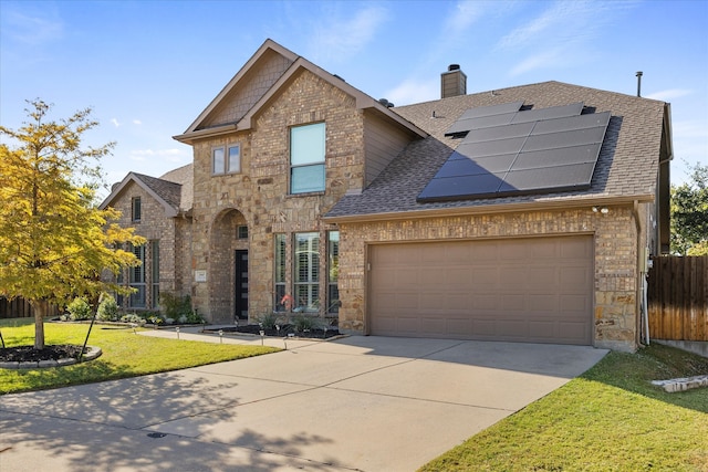 view of front of property featuring a front yard and solar panels