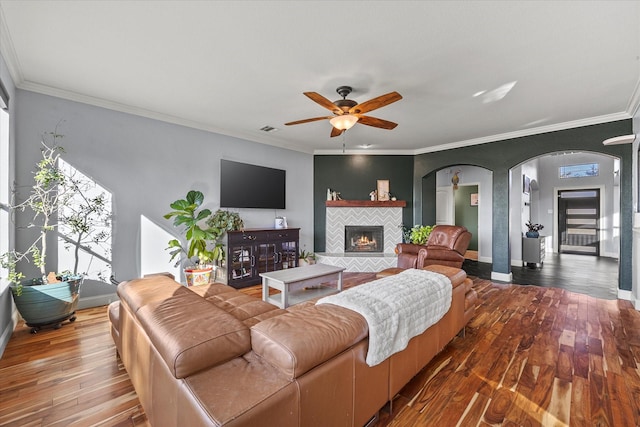 living room featuring crown molding, a wealth of natural light, ceiling fan, and hardwood / wood-style flooring