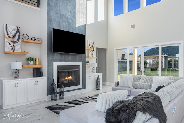 living room with a large fireplace and a high ceiling