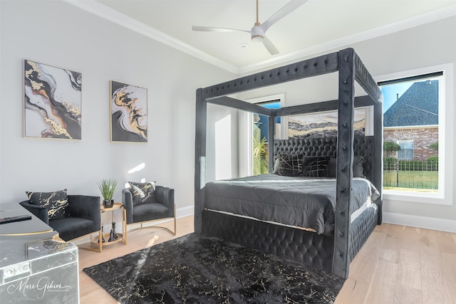 bedroom featuring ceiling fan, crown molding, multiple windows, and hardwood / wood-style floors