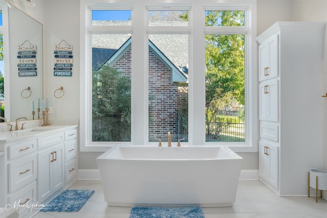 bathroom with a healthy amount of sunlight, vanity, and a bath