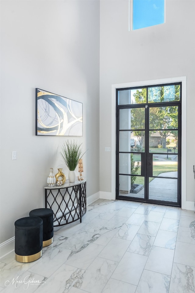 foyer entrance featuring a high ceiling and french doors