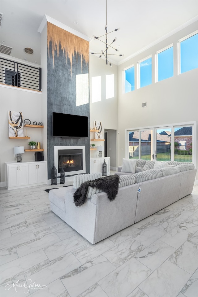 living room featuring a large fireplace, a towering ceiling, and a healthy amount of sunlight