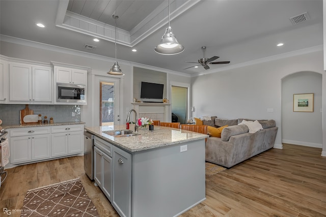 kitchen with white cabinets, stainless steel appliances, sink, and light wood-type flooring