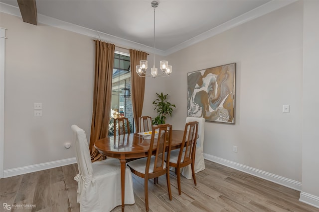 dining room with light hardwood / wood-style floors, ornamental molding, and a chandelier