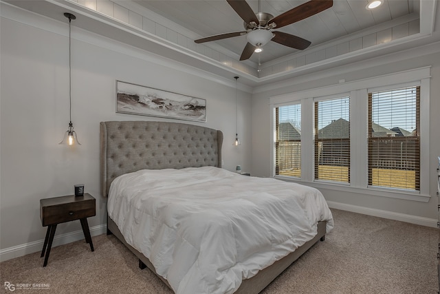 bedroom with ceiling fan, a raised ceiling, and carpet flooring