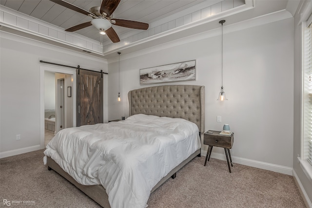 carpeted bedroom with wood ceiling, a barn door, a raised ceiling, ensuite bathroom, and ceiling fan