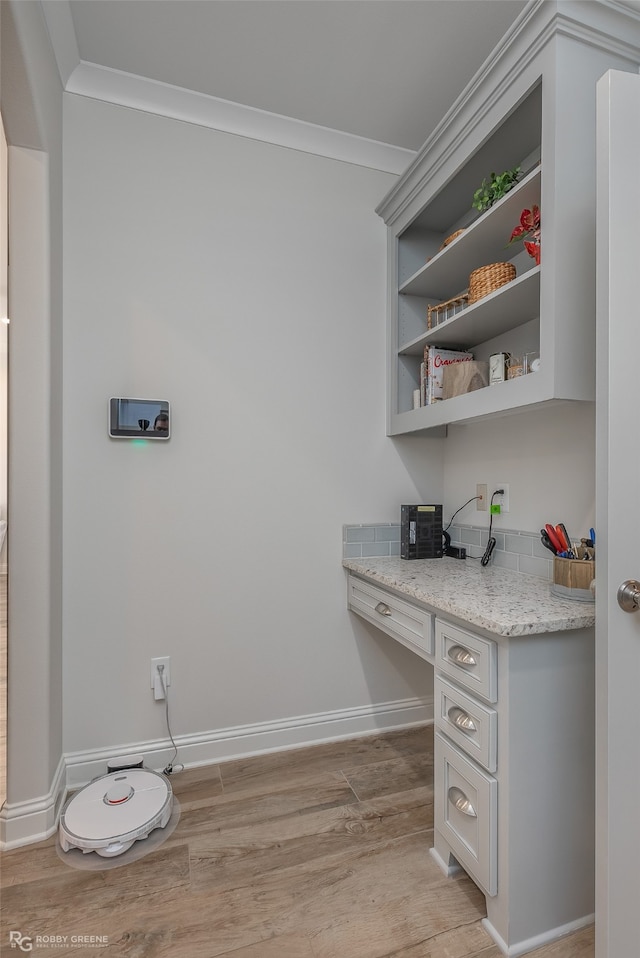 washroom with ornamental molding and light hardwood / wood-style flooring