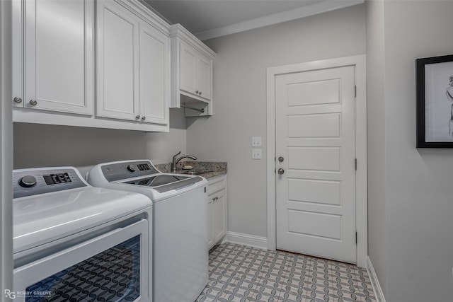 laundry area featuring cabinets, sink, and washer and clothes dryer