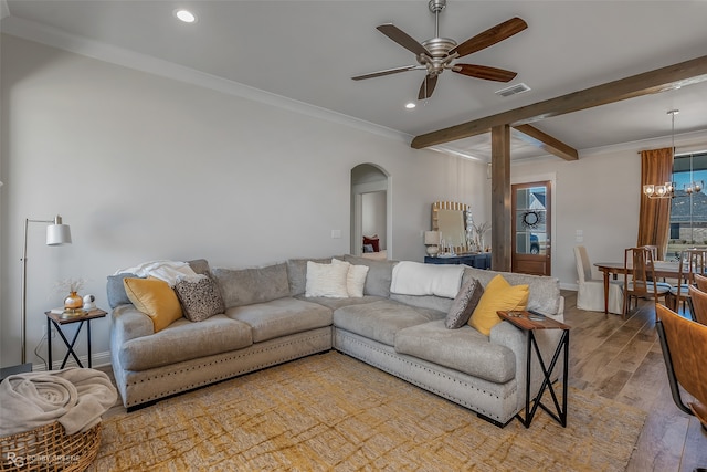 living room with ornamental molding, hardwood / wood-style floors, beamed ceiling, and ceiling fan with notable chandelier