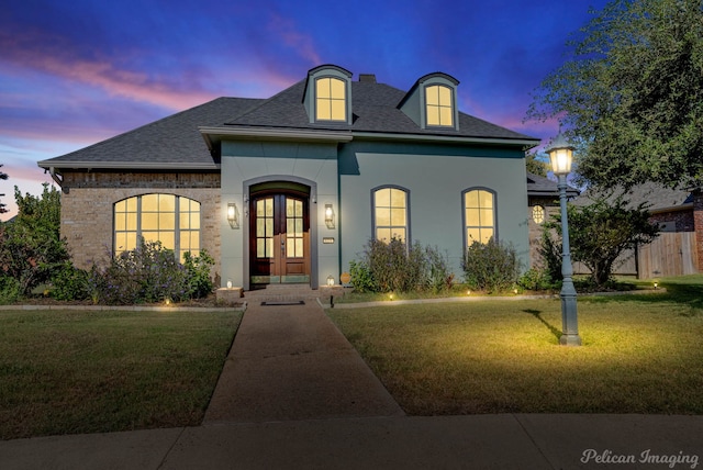 french country style house with french doors and a lawn