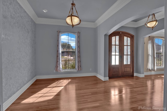 interior space featuring wood-type flooring, ornamental molding, and plenty of natural light