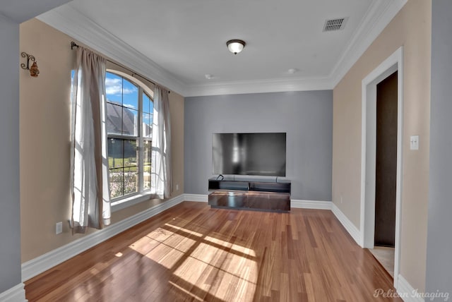 unfurnished living room with crown molding and wood-type flooring