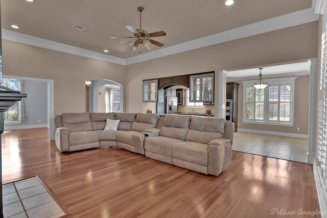 living room featuring light hardwood / wood-style flooring, crown molding, and ceiling fan