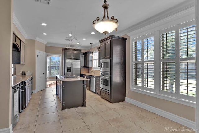 kitchen with appliances with stainless steel finishes, a center island, dark brown cabinets, and a wealth of natural light