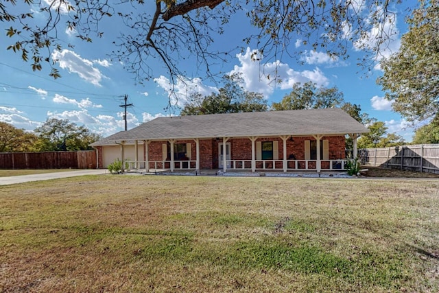 ranch-style home featuring a front lawn, covered porch, and a garage