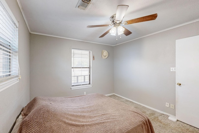 unfurnished bedroom featuring ceiling fan, crown molding, and carpet floors