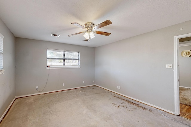 empty room with ceiling fan, a textured ceiling, and concrete flooring