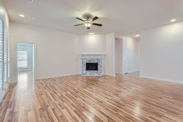 unfurnished living room with light hardwood / wood-style floors, a fireplace, and ceiling fan