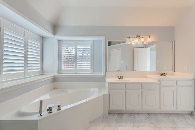 bathroom featuring vanity, lofted ceiling, and a bathtub