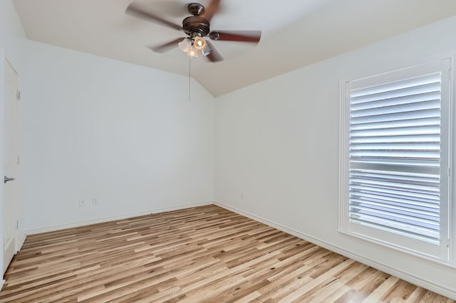 spare room with ceiling fan, vaulted ceiling, and light hardwood / wood-style flooring