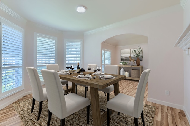 dining area featuring ornamental molding and light wood-type flooring