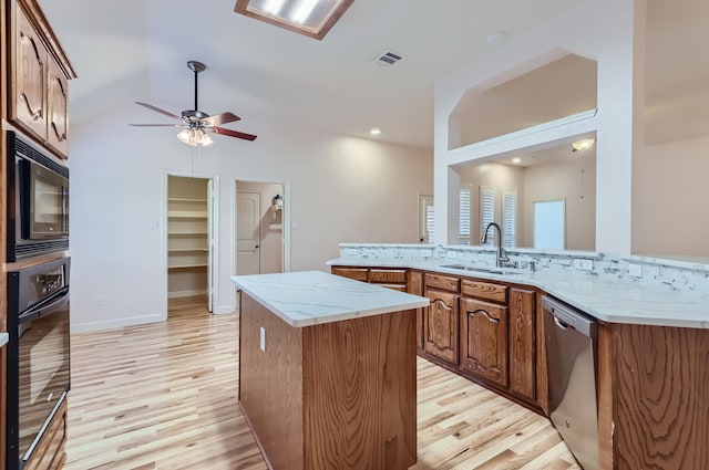 kitchen with light hardwood / wood-style floors, appliances with stainless steel finishes, lofted ceiling, and kitchen peninsula