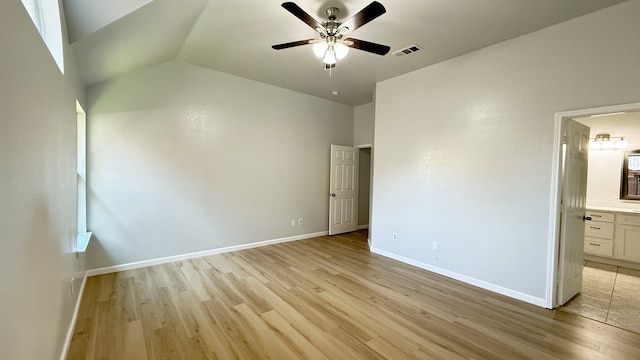 unfurnished bedroom featuring ensuite bathroom, lofted ceiling, light hardwood / wood-style flooring, and ceiling fan