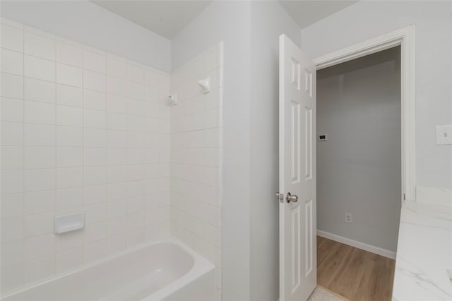 bathroom featuring vanity, tiled shower / bath combo, and hardwood / wood-style flooring