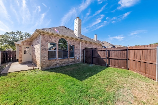 back of property with a yard and a patio