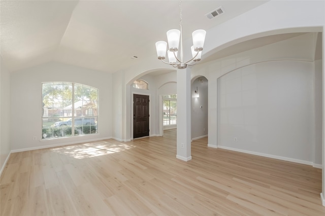 interior space featuring an inviting chandelier, vaulted ceiling, light hardwood / wood-style flooring, and a healthy amount of sunlight