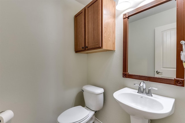 half bathroom featuring a sink and toilet