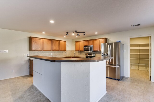 kitchen featuring decorative light fixtures, stainless steel appliances, a center island, and a chandelier