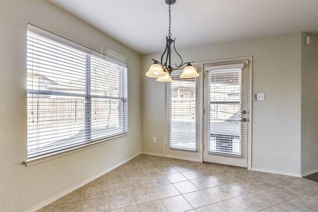 unfurnished dining area with light tile patterned floors, baseboards, and an inviting chandelier