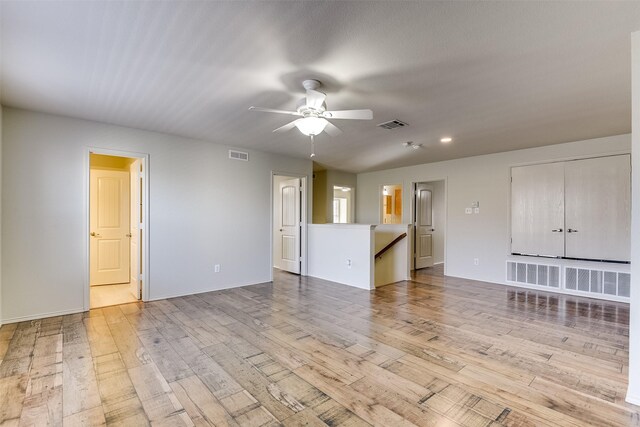 unfurnished living room featuring a ceiling fan, visible vents, and light wood-type flooring