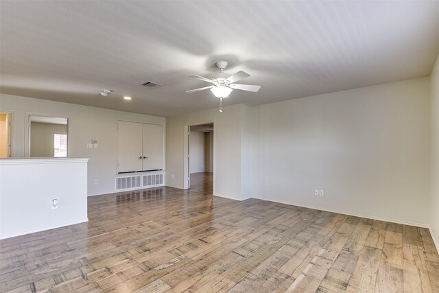 empty room featuring visible vents, baseboards, a ceiling fan, and wood finished floors