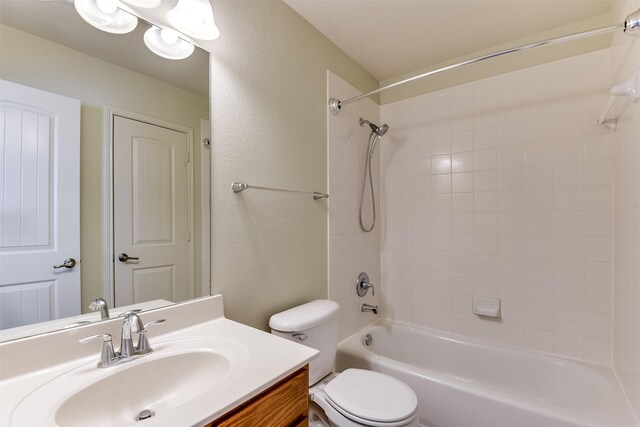 full bath featuring bathing tub / shower combination, toilet, vanity, and a textured wall