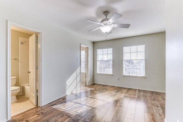 empty room featuring ceiling fan, baseboards, and wood finished floors