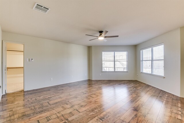 spare room featuring visible vents, ceiling fan, and wood finished floors