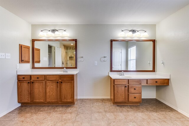 bathroom featuring two vanities, baseboards, and a sink