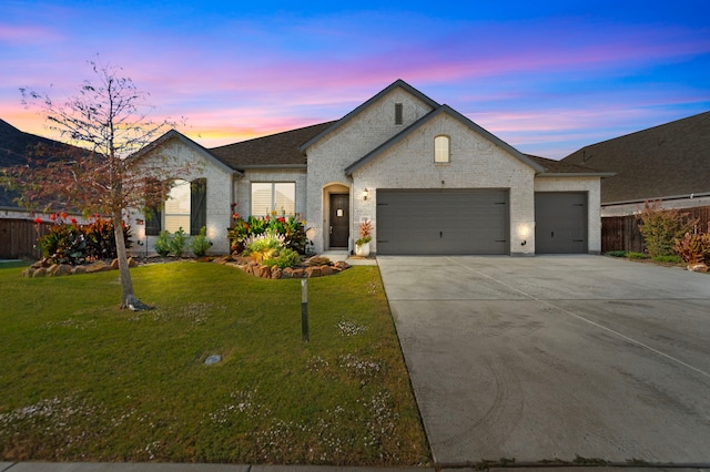 french provincial home with a yard and a garage