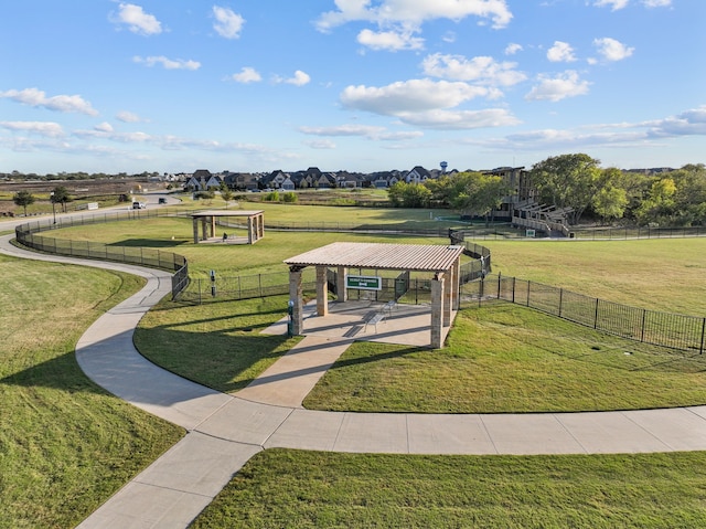 view of property's community featuring a gazebo, a rural view, a yard, and fence