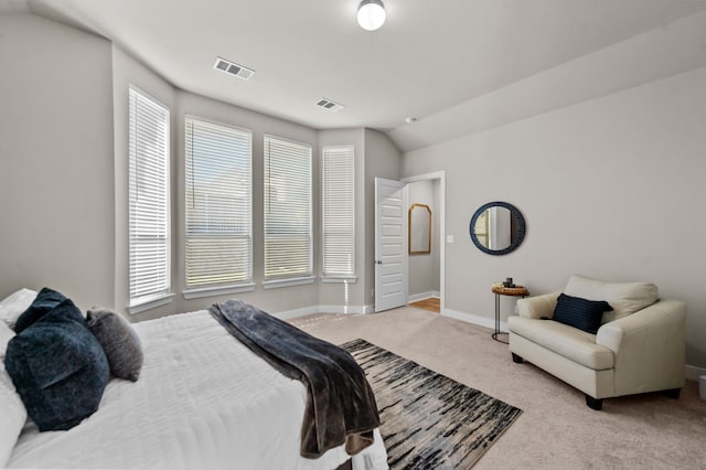 bedroom featuring visible vents, baseboards, light colored carpet, and vaulted ceiling